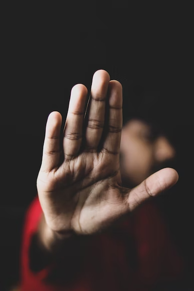 a man holding his palm in the air signaling stop