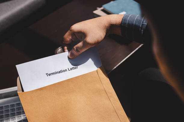 a man pulling out the termination letter from the brown envelope