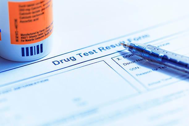 a pen on a drug test result form