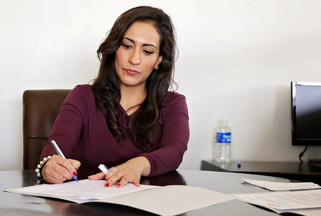a woman signing some documents