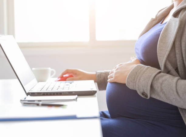 a pregnant woman working with a laptop