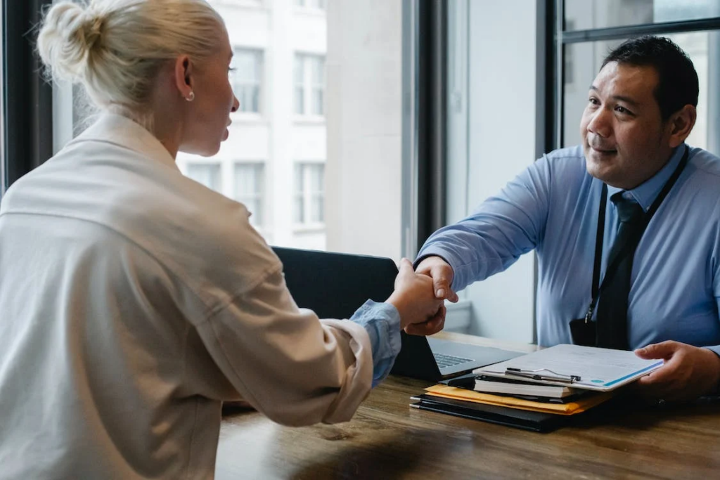 a man and a woman  in business attires shaking hands