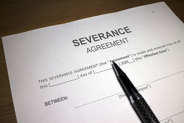 a severance pay agreement on the table with a pen on it