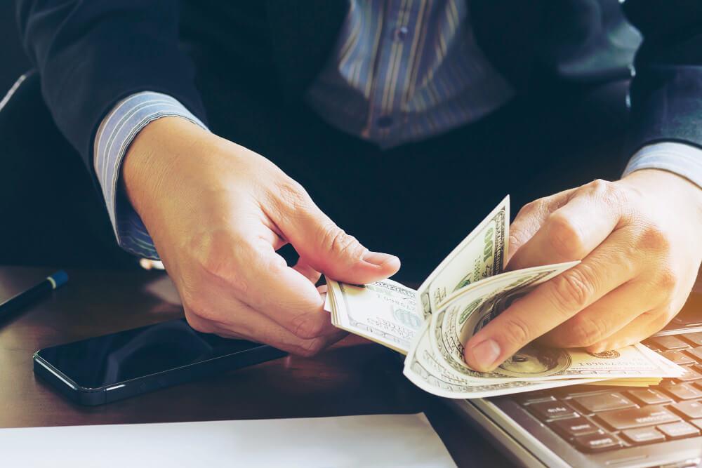 a man in formal attire counting money