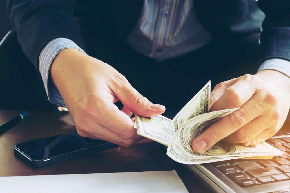 a photo showing the hands of a person counting some money