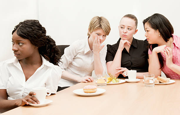 a group of woman discriminating on a woman with darker skin tone